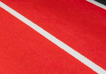 The gym's red sprint track with white lane lines