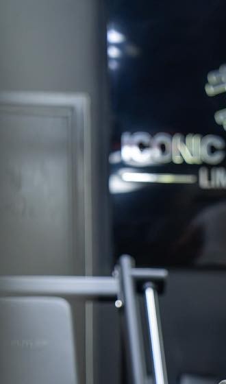 The chrome Iconic Fitness sign on the gym's black wall